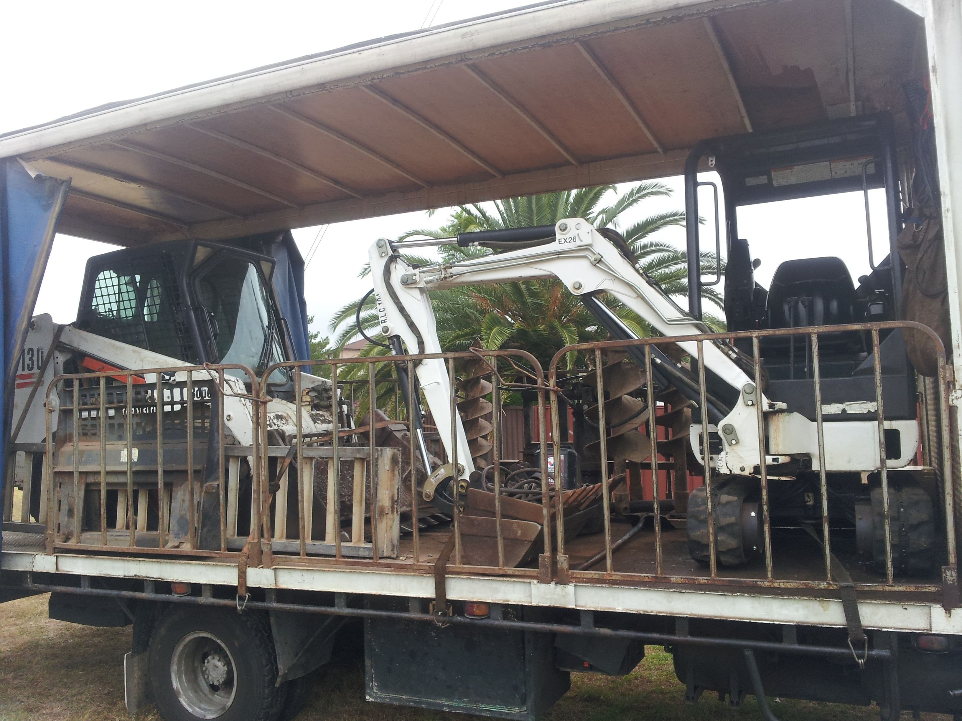typical excavator bobcat combination with auger and forks